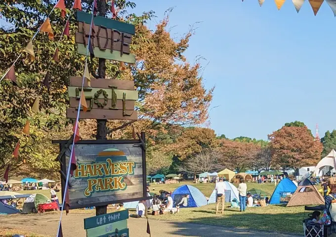 HARVEST PARKの看板と背景に見えるテントや木々のバナー